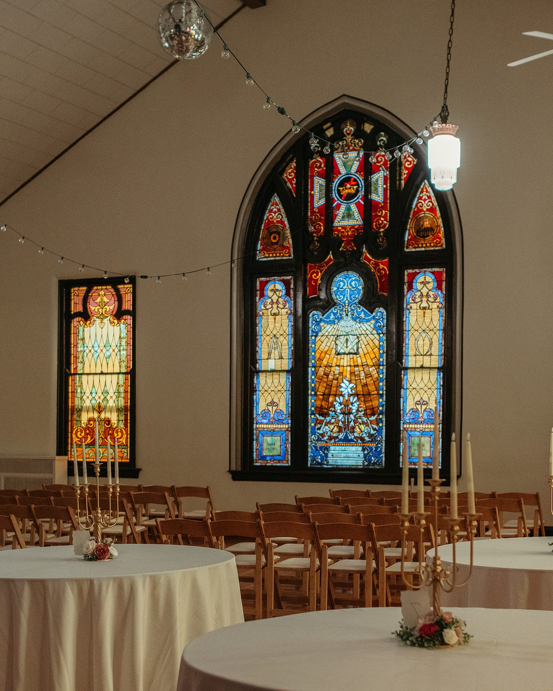 The Sanctuary set for a ceremony, with original stained-glass windows and vaulted ceiling